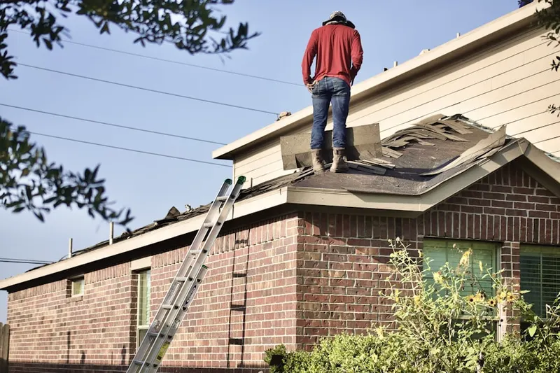 Professional roofer working on a residential roof in Pueblo Del Rio Public Housing